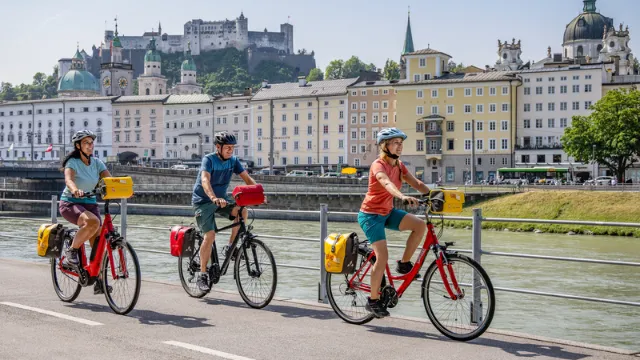 Gruppe von Radfahrern in Salzburg am Giselakai entlang fahrend